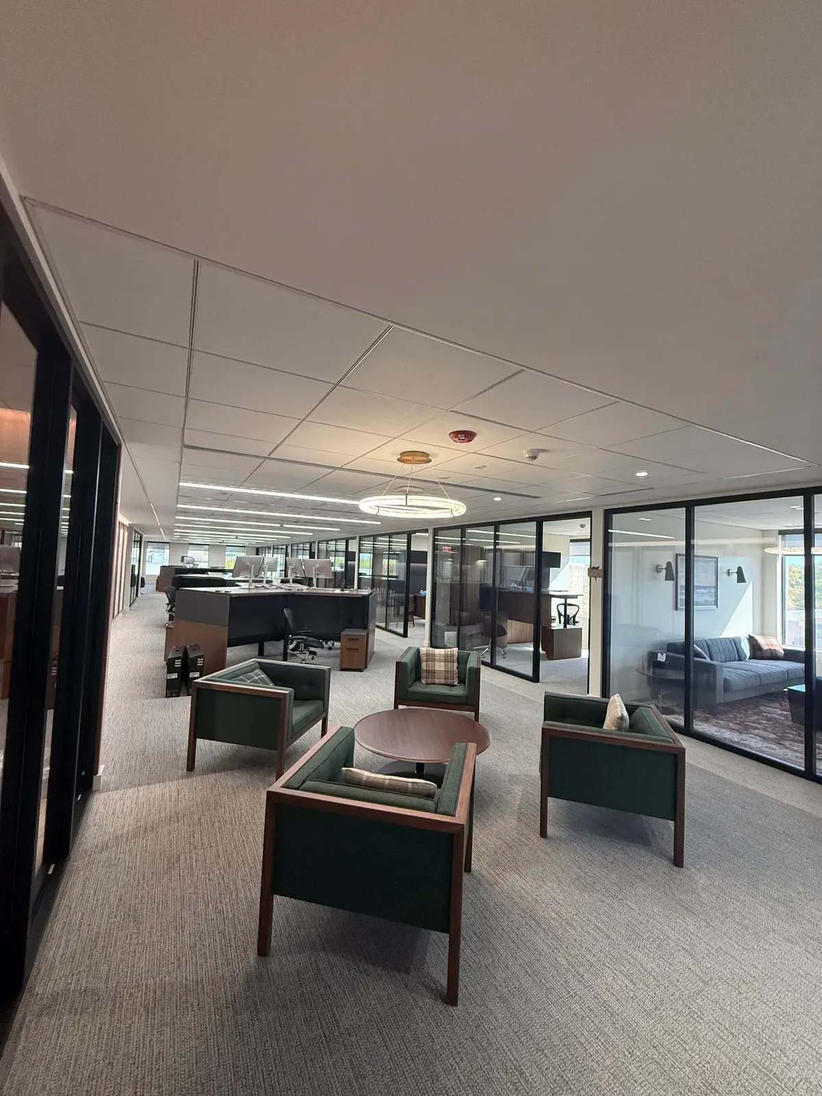 Modern commercial office with linear LED lighting glass meeting rooms and lounge seating